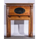 Mahogany fire surround, inset with oval mirror above a mantel shelf, flanked by fluted columns,