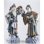 Pair of Chinese pottery male and female figures, each holding a circular disc,