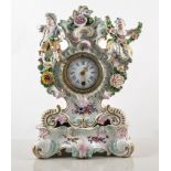 A Meissen style porcelain mantel clock, floral encrusted two figures with garlands of fowers,