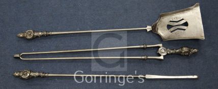 A set of three George III style steel fire irons, with rococo scroll handles, shovel 29.5in.