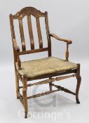 A 19th century French beech and fruitwood elbow chair, with rush seat, H.3ft 4in.