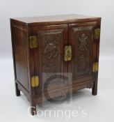 A Chinese rosewood cabinet, the two doors carved with vases and pots, W.2ft 10in.