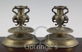 A pair of Italian Renaissance Venetian bronze candlesticks, 16th/17th century, with scroll handles