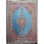 A Persian Tabriz style carpet, with central lozenge shaped floral medallion on a pale blue ground,