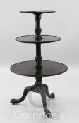 A George III mahogany three tier dumb waiter, with carved tripod base, W.2ft 2in.