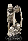 A Japanese ivory okimono of Ashinaga and Tenaga, Meiji period, the two figures holding aloft a