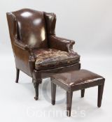 A Georgian style mahogany and brown leather wing armchair, with an associated stool