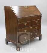 A George I oak bureau, stepped interior above a concealed well and two short and two long drawers,