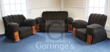 An Art Deco three piece suite, with fluted walnut stiles, re-upholstered in period correct fabric