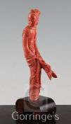 A Chinese coral figure of a beautiful lady, finely carved holding a sprig of flowers and leaves,