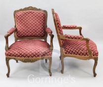 A pair of Louis XV style walnut fauteuils, with scroll carved frames