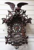 A Black Forest carved cuckoo clock with eagle surmount. 35in.