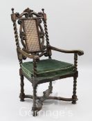 A Carolean style walnut elbow chair, with caned back and cushion seat