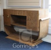 An Art Deco, probably Epstein, burr wood serving table, with central drawer and two cupboards on U