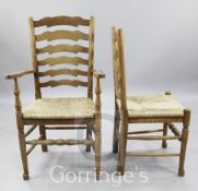 A set of twelve oak ladderback dining chairs, including two carvers, with rush seats