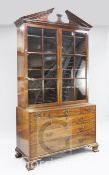 A George III mahogany bookcase, with broken arched pediment and two astragal glazed doors above an