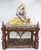 A large German 19th century Ecclesiastical plaster figure of a seated woman mourning beside an