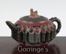 A Chinese Yixing pottery teapot and cover, modelled around the body with sections of bamboo, the