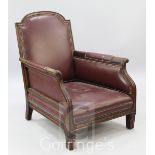 An Edwardian red leather upholstered mahogany framed armchair, with leaf carved arms, on short