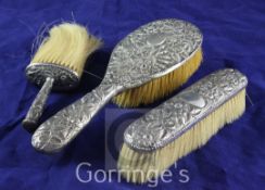 Three late Victorian repousse silver mounted dressing table brushes, Nathan & Hayes, Chester, 1897