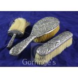 Three late Victorian repousse silver mounted dressing table brushes, Nathan & Hayes, Chester, 1897