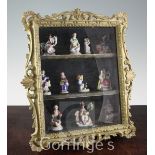 A collection of Chelsea style hard paste porcelain toy figures, contained in a green painted and