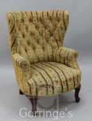 A George I style tub shaped buttoned armchair, on cabriole legs