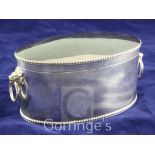 A George V silver oval biscuit box, with hinged lid, gadrooned borders and lion mask ring handles,