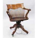 A Victorian mahogany swivel desk chair, with a spindle turned back, raised on four splayed legs with