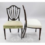 A pair of George III Hepplewhite period shield back chairs, with fluted husk topped spars, over