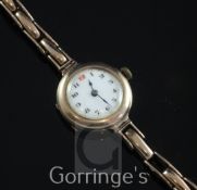 A George V 9ct gold manual wind wrist watch, with Arabic dial, on a 9ct gold flexi-link bracelet (