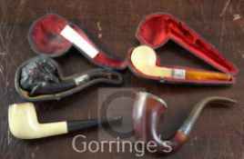 Four Meerschaum and wood pipes, including a female carved cherrywood Nubian head, silver mounted,