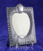 A late Victorian repousse silver photograph frame by William Comyns, of rectangular form, with heart