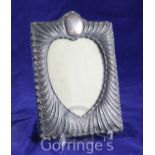 A late Victorian repousse silver photograph frame by William Comyns, of rectangular form, with heart