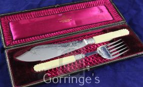 A pair of Victorian carved ivory handled silver plated fish servers, with engraved decoration, in