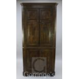 A late 18th century oak standing corner cupboard, fitted with two pairs of fielded panelled doors,