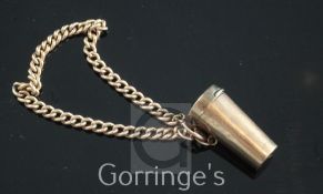 An early 20th century 9ct gold cased telescopic cigarette holder, on a 9ct gold chain, with amberoid