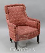 An Edwardian mahogany framed nursing chair. upholstered in floral decorated pink damask, with