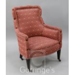 An Edwardian mahogany framed nursing chair. upholstered in floral decorated pink damask, with