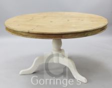 A large circular topped pine table, on white painted tripod base, diameter 4ft 6in.