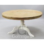 A large circular topped pine table, on white painted tripod base, diameter 4ft 6in.