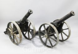 A pair of iron field cannons, the 35 inch barrels with 1¾ inch bore, raised on spoked iron