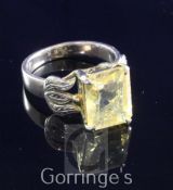 A 14ct gold and solitaire citrine set dress ring, with emerald cut stone and engraved foliate