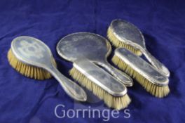 A matched George V five piece silver dressing table set with engraved decoration, various dates &