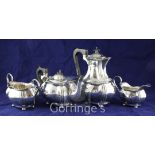An Edwardian four piece silver tea set, of oval bombe shape, with fluted angle and ebonised handles,