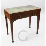 An Edwardian mahogany writing table, with green and gilt leather inset top, fitted long drawer, on