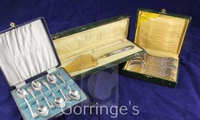 A cased set of twelve French plated teaspoons, a French silver handled cake slice and a cased set of