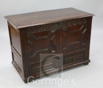 A 17th century oak mule chest, with foliate carved frieze, geometric panelled front and base drawer,