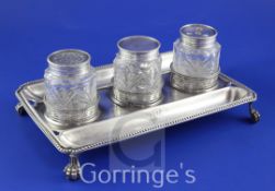 A George III silver inkstand, of rectangular form, with beaded border, engraved monogram and three