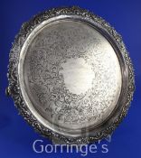 A late Victorian silver circular salver, with shell and scroll border and engraved with scrolling